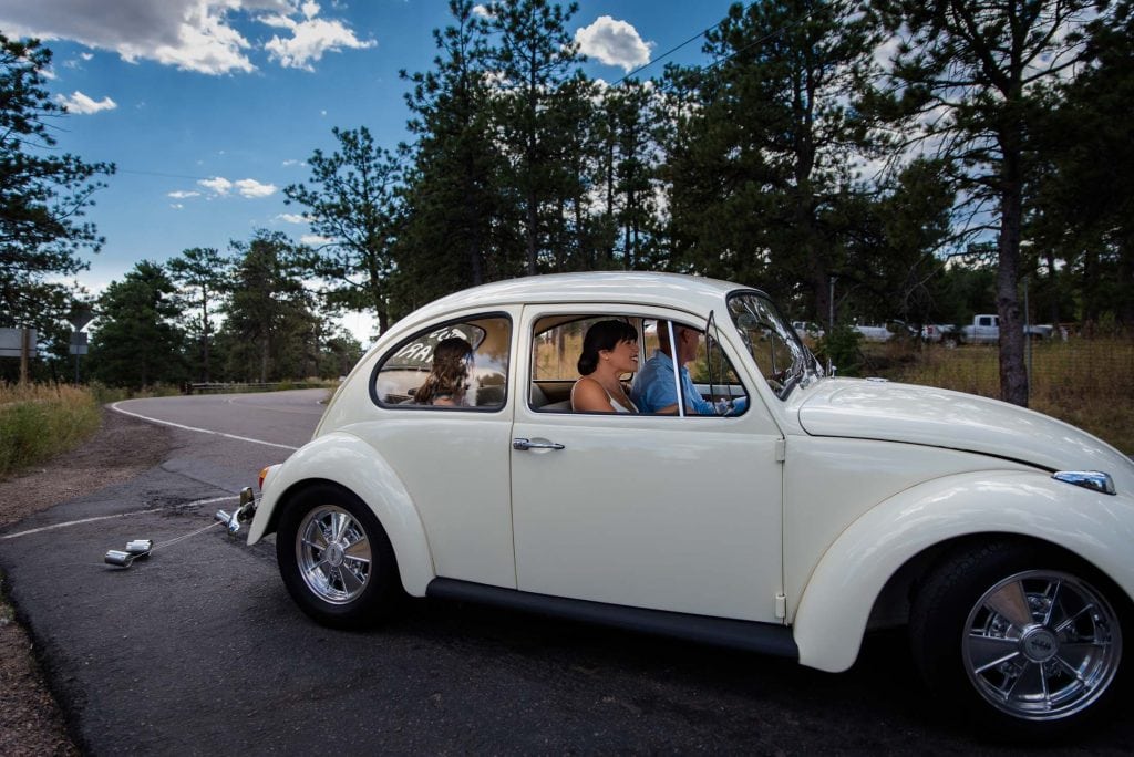 a couple drives away from their elopement in their vintage white volkswagen beetle