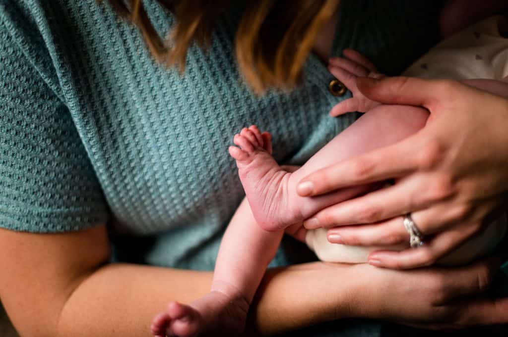 Baby feet held by mom