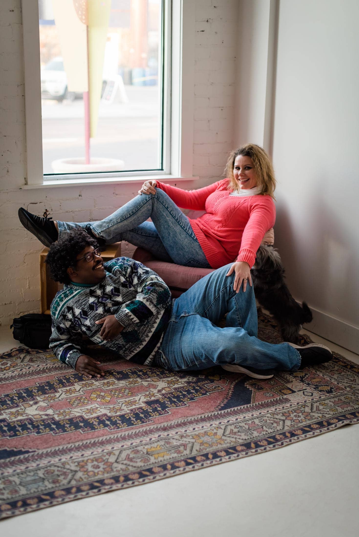 Couple does awkward poses in a photo studio in Denver, Colorado for their 80s styled engagement session
