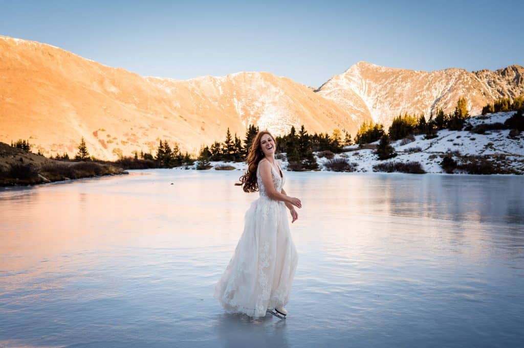 a bride ice skates on a frozen alpine lake at her Colorado elopement