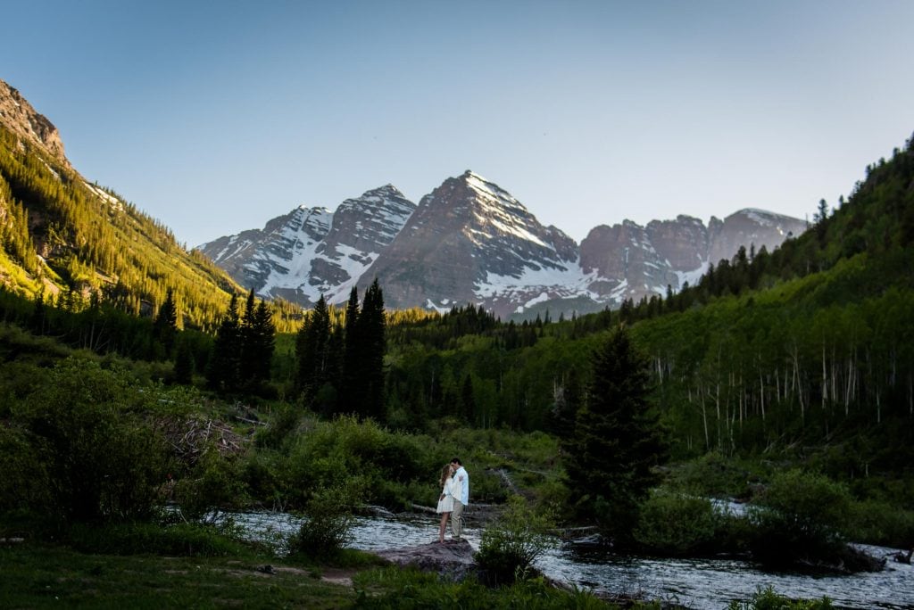 a couple snuggles under the maroon bells in Aspen at sunset after their elopement