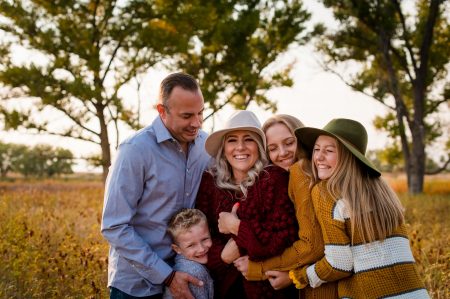 a family snuggles up in the golden sunlight at their family lifestyle photography session in Denver