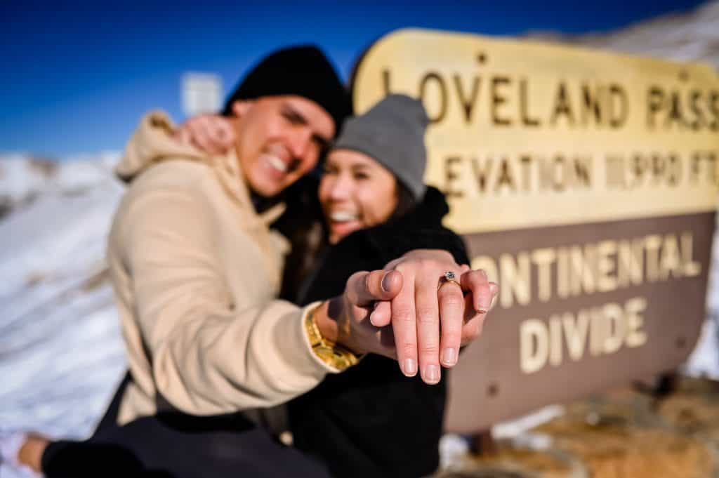 a couple snuggle on Loveland Pass after he proposed at Loveland Ski Area