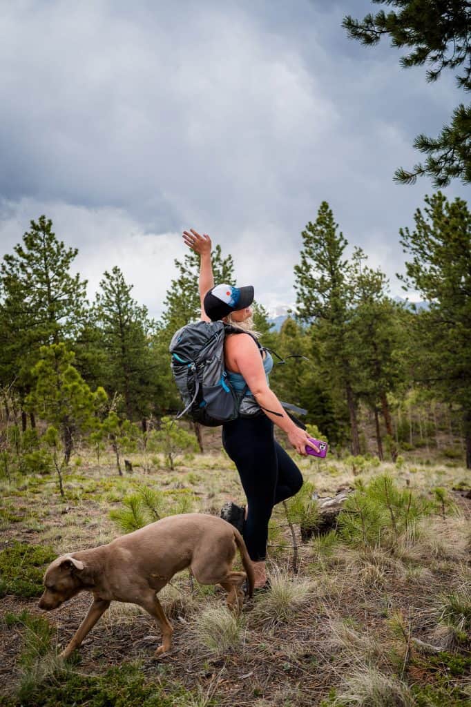 a girl is having fun hiking with her dogs in Colorado