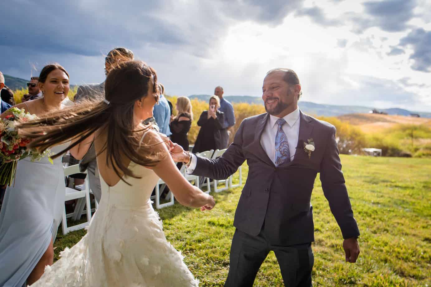 The couple dances down their ceremony recessional celebrating having just exchanged vows at this Steamboat Springs Wedding
