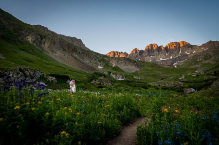 a couple snuggles under the alpenglow in American Basin near Handies Peak for their engagement session