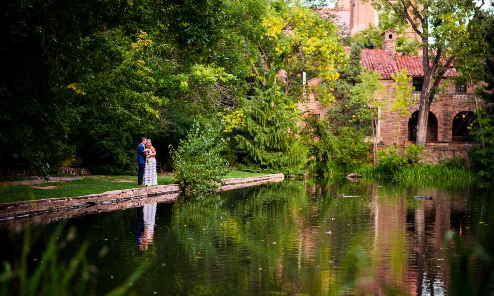 couple stands near a lake on CU Boulder campus after their wedding at Koenig Alumni Center