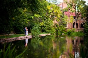 couple stands near a lake on CU Boulder campus after their wedding at Koenig Alumni Center