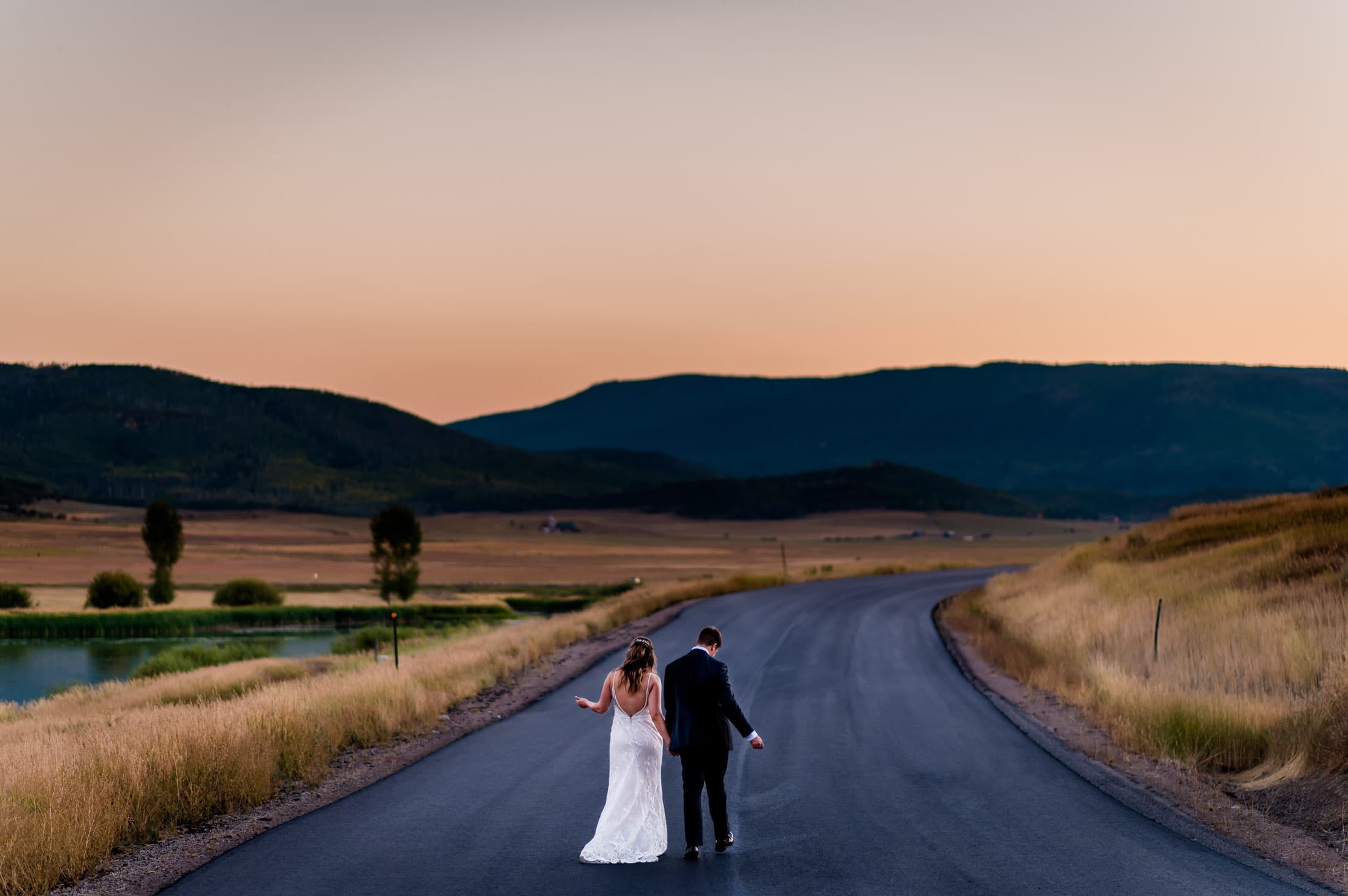 a couple dances down the road during sunset after their Steamboat Springs elopement in the mountains