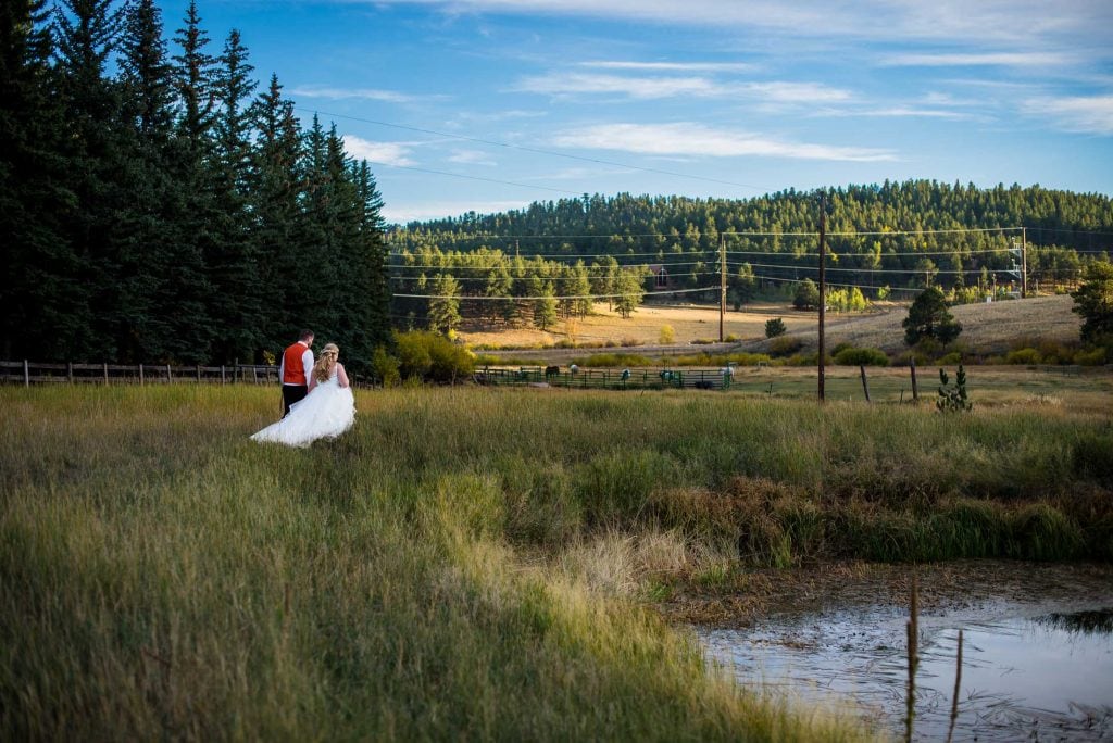a couple walks together at their Deer Creek Valley Ranch Wedding in the mountains of Colorado