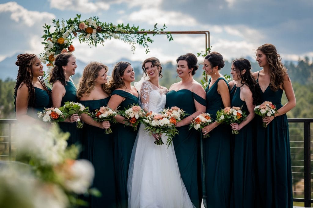 a bride and her maids laugh together at her mountain wedding in Colorado