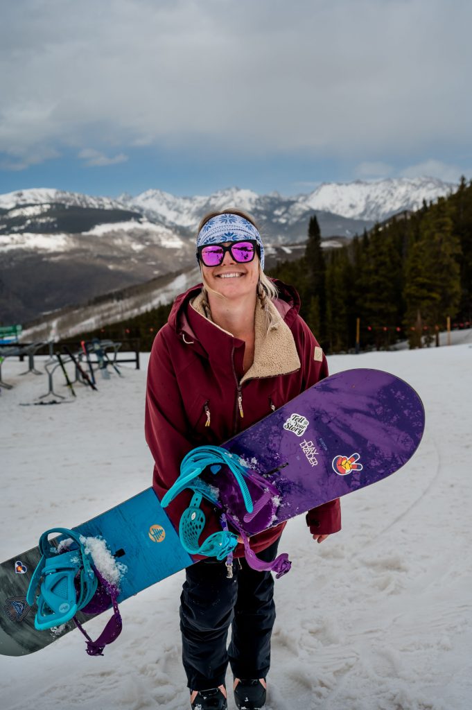 a ski & snowboard wedding photographer smiles at the camera while hanging at Vail ski resort in Colorado