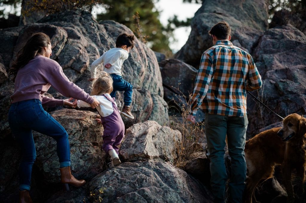 a family climbs boulders together at their adventure family photography session in Colorado