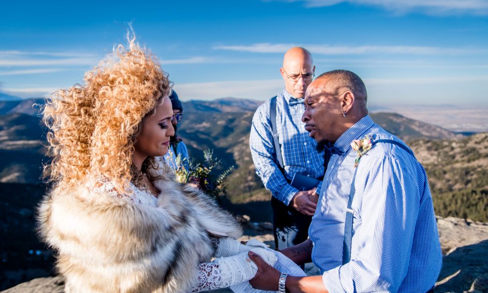 A couple exchanges vows on top of a windy mountain in Colorado