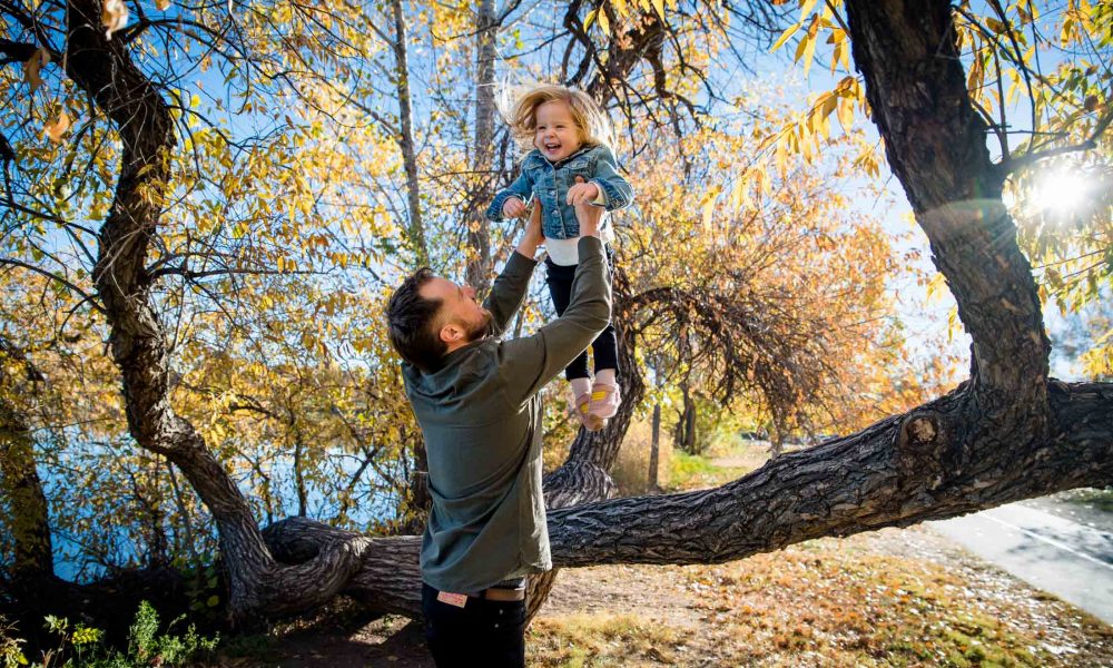 a father playfully tosses his toddler in the air