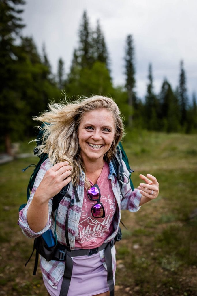 Adventure photographer Nat Moore smiles at the camera on the trail in Colorado