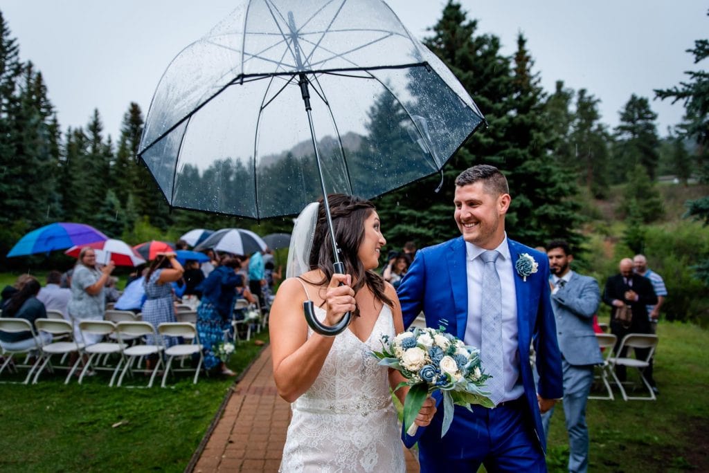 a couple exits their rainy wedding ceremony at Wedgewood Mountain View Ranch in Pine, Colorado