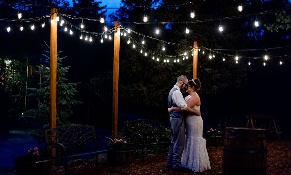 a couple dances under the string lights during blue hour at their Meadow Creek Lodge wedding in Colorado