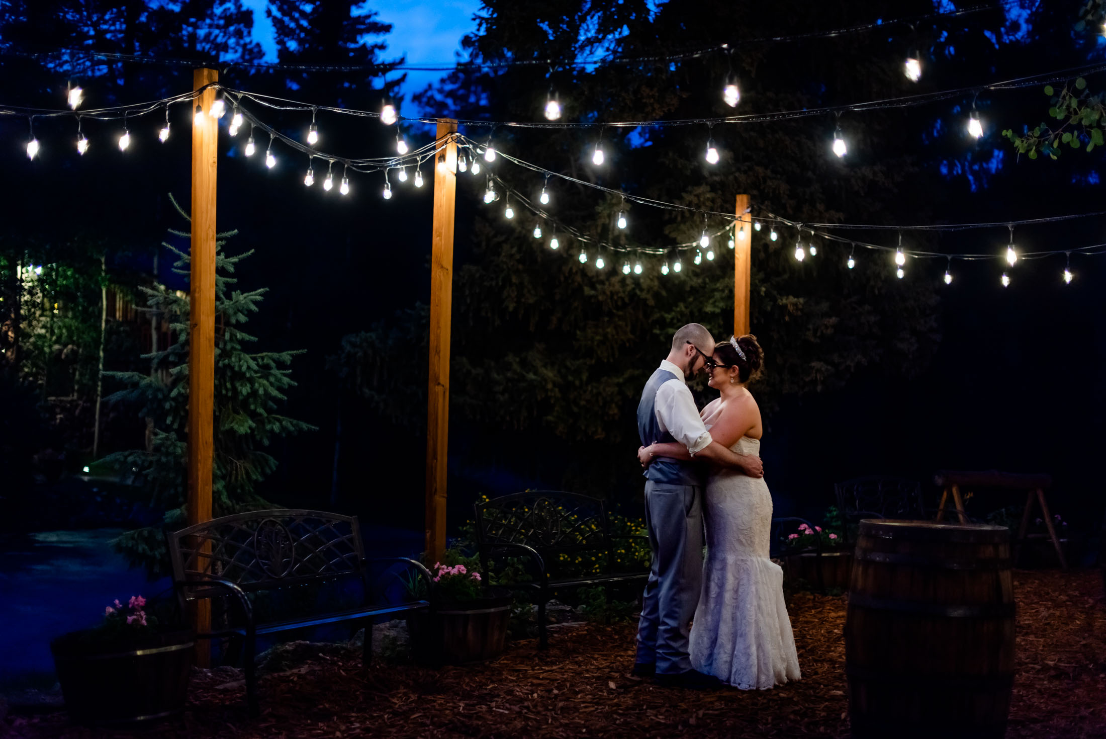 a couple dances under the string lights during blue hour at their Meadow Creek Lodge wedding in Colorado
