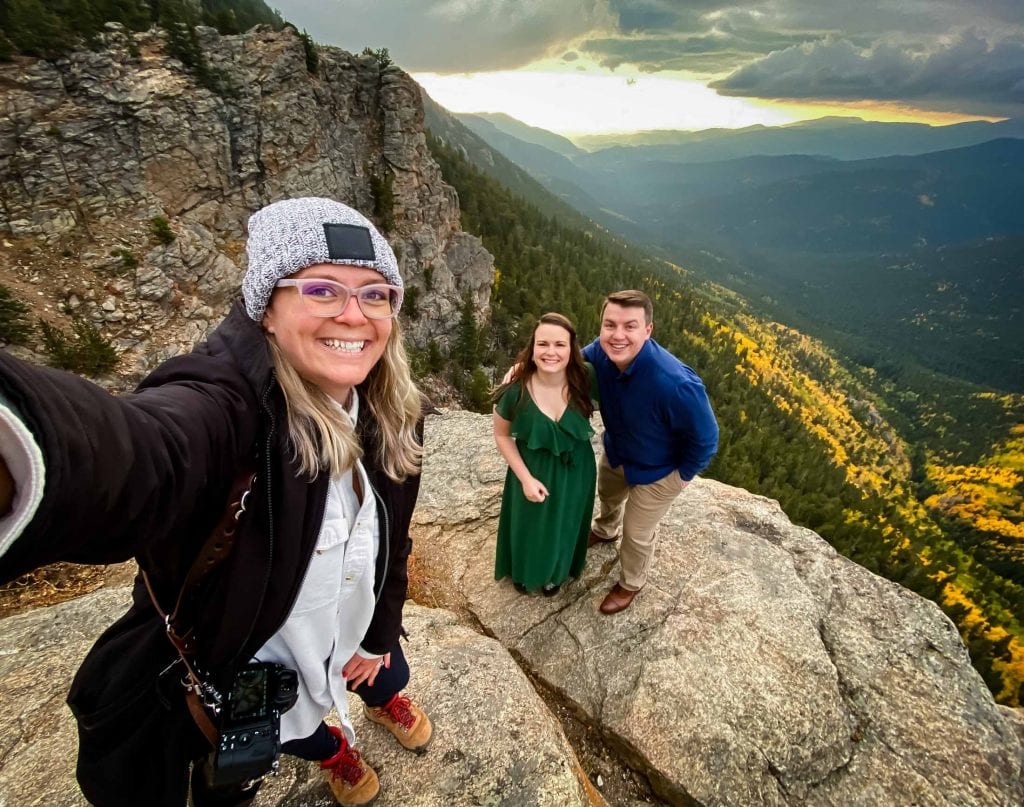 Nat Moore Photography and her engagement couple hang out on a cliff side in the Rocky Mountains