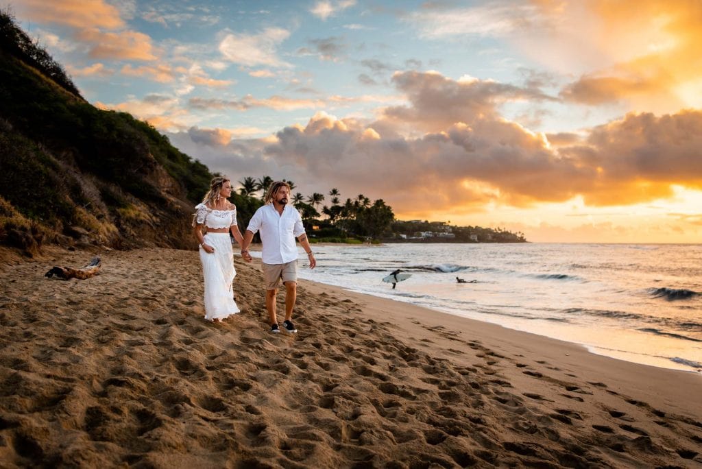 a couple explores the beaches of Oahu during sunrise at their laid back elopement 