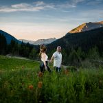 a couple walks through wildflowers in front of Mt Crested Butte in Colorado