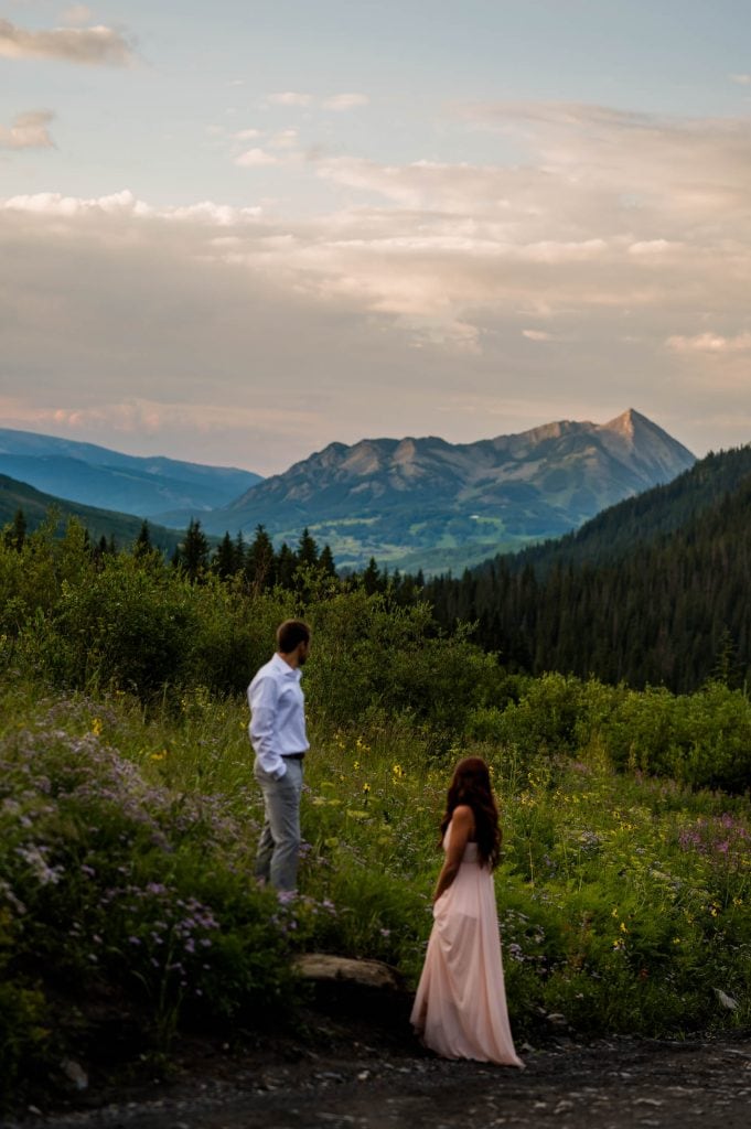 a couple stands off the side of Gothic road with My Crested Butte in the background. 