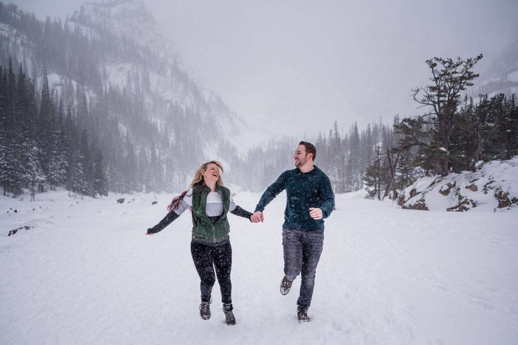 a couple runs in a blizzard at Dream Lake in RMNP for their engagement photography