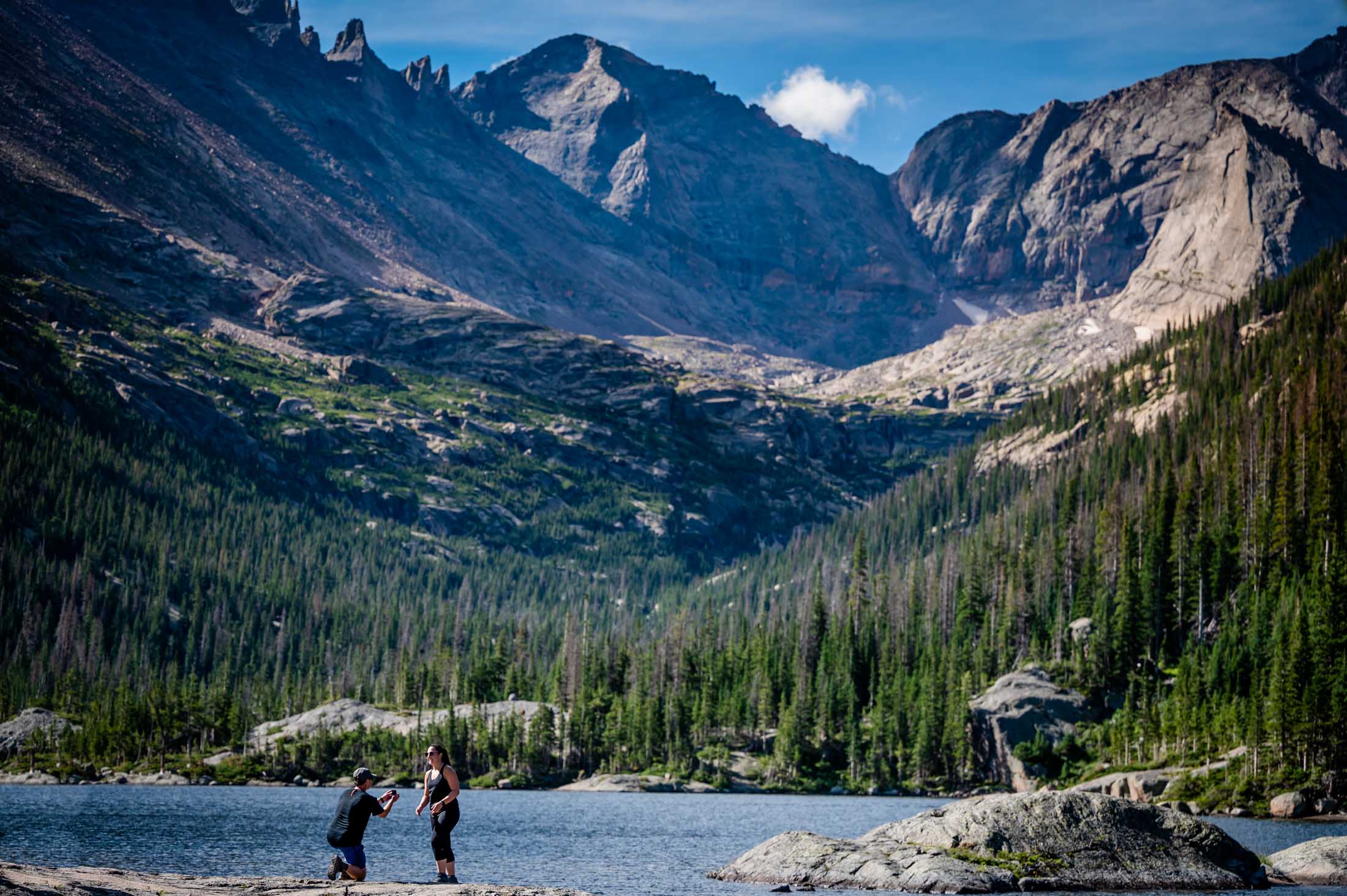 a couple proposes as Mill Lake in RMNP with a photographer for this adventure proposal in RMNP