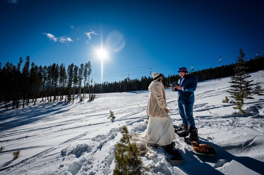snowboarders exchange vows on the side of the run at their wedding on mountain at Breckenridge ski resort