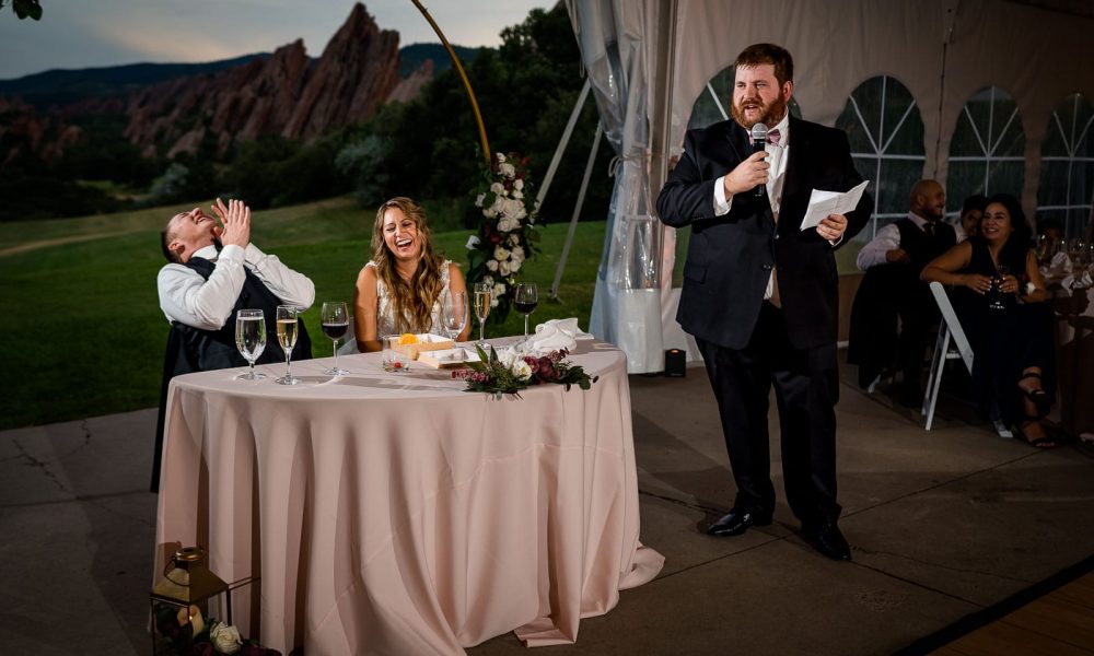 the best man makes the bride and groom laugh at their wedding during his speech at Arrowhead Golf Club at their Colorado wedding