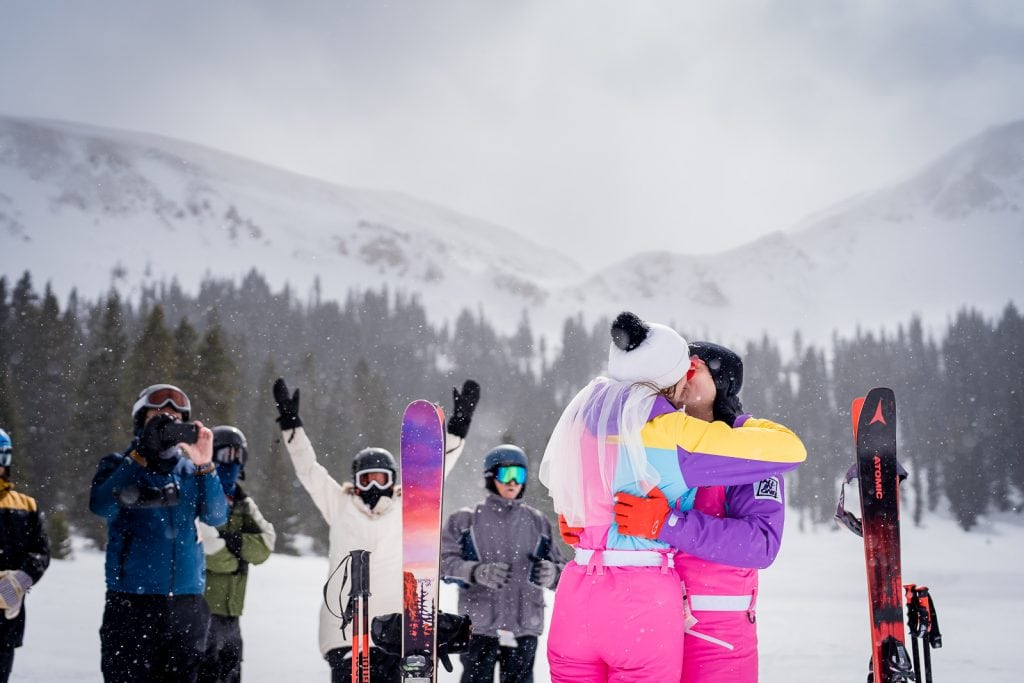 a couple shares their first kiss at their slopeside ski wedding at Loveland Ski Area