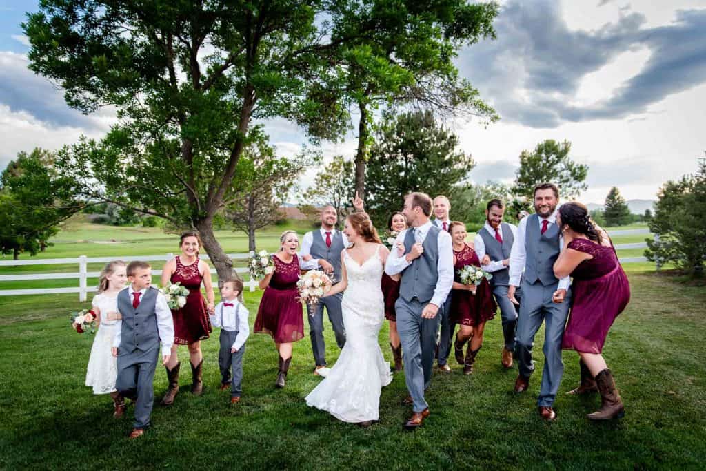 a wedding party has fun as they work with their photographer for some fun moments together to celebrate their newly married friends