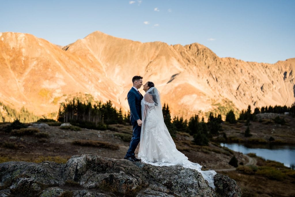 A couple shares an intimate moment during their elopement photos on Loveland Pass during sunset