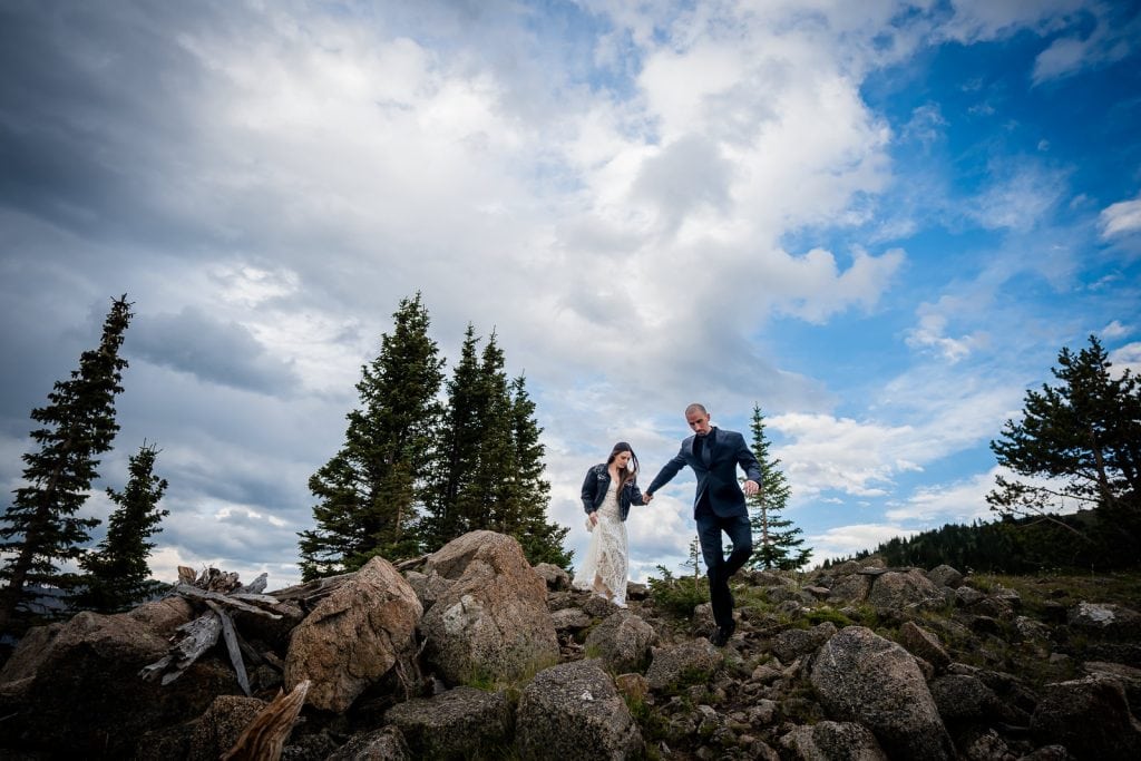 a couple hikes down a mountain in the collegiate peaks hand in hand after their elopement