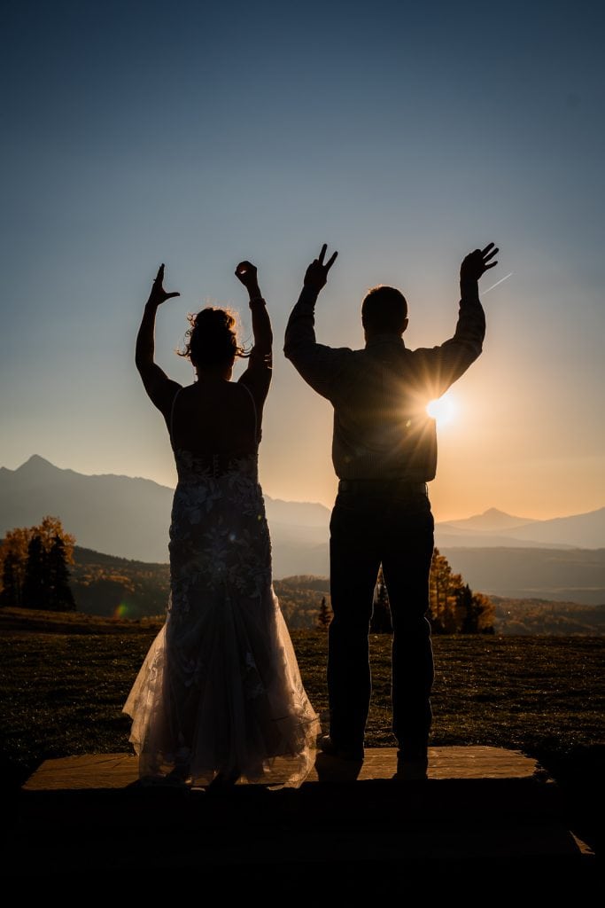 a couple make L O V E with their hand while watching the sunset on their wedding day in Telluride, Colorado