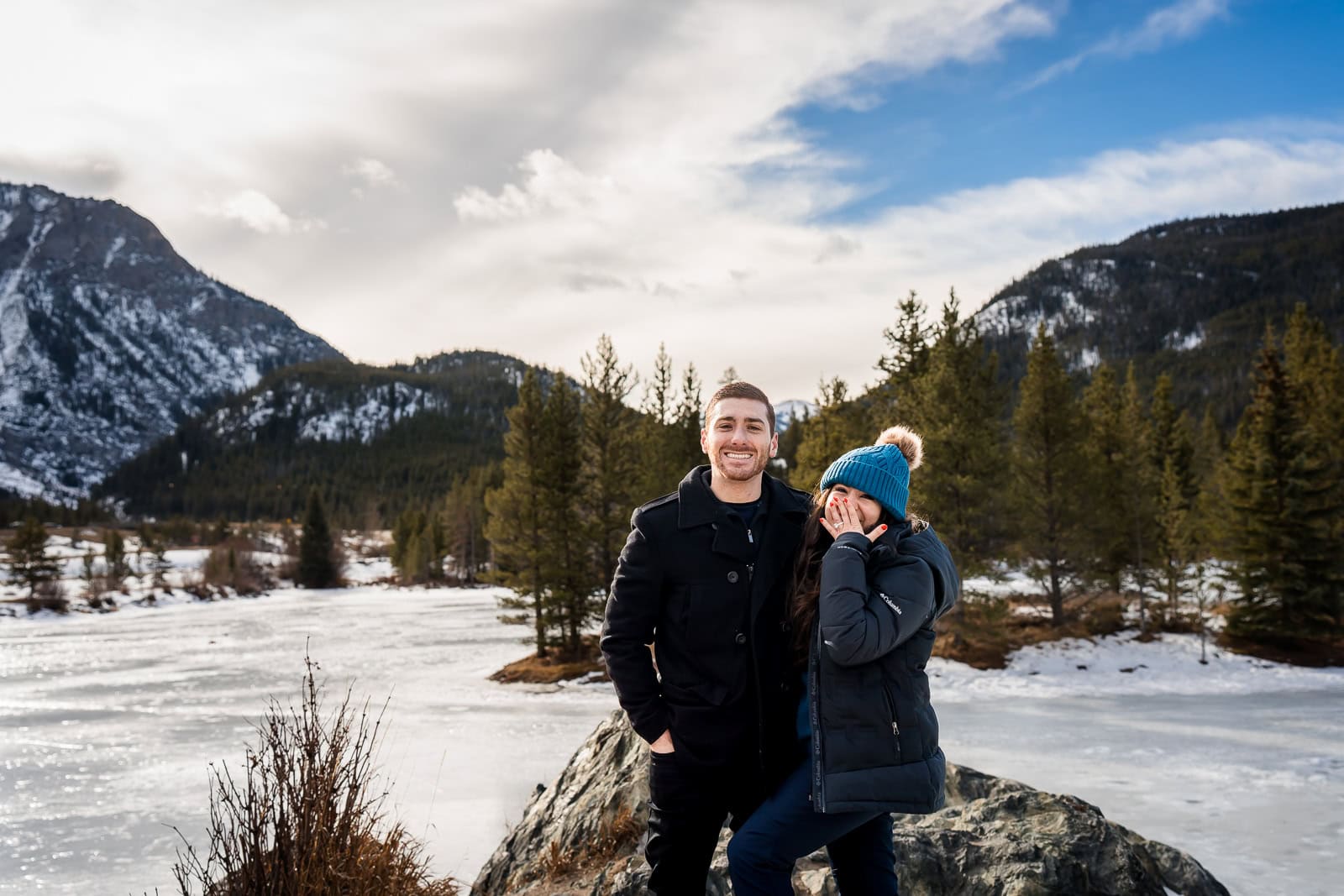 a couple poses together in excitement after their proposal at Officers Gulch in Summit County Colorado
